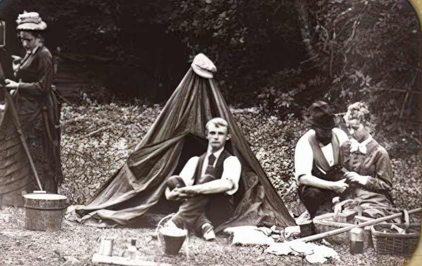 This is a collodion negative that has been mounted as a lantern slide. It has been labeled by the photographer “Wet col neg Wet col positive”. The paper mat tells us it was made in 1873 in Belvidere, New Jersey. It names the young men (it appears that the young women did not rate naming) are H. W. Hazard and John C. Browne. The camera peeks out of the mat on the left side but the dark tent, buckets, and other supplies give us a delightful window on what was involved in an afternoon of photographing in 1873.