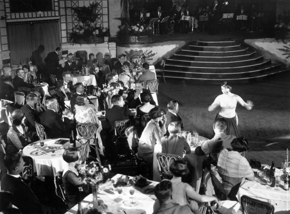 #24 Diners and a cabaret performer at Palm Beach Cafe, London, 1926.