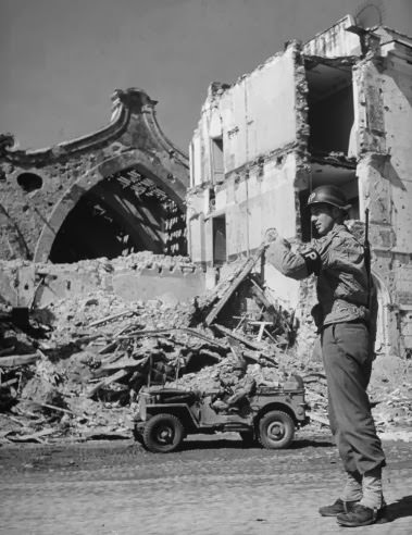 #29 Military Policeman Ray E. Kellogg directing traffic in Anzio, 1944.