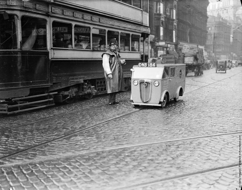 A tiny Rytecraft van, Britain’s smallest, travelling along Deansgate in Manchester. The vehicle is powered by a 2 1/2 hp engine, travels 80 miles on a gallon of petrol, carries nearly 600 pounds and has a top speed of 50 mph. 17th February 1937.