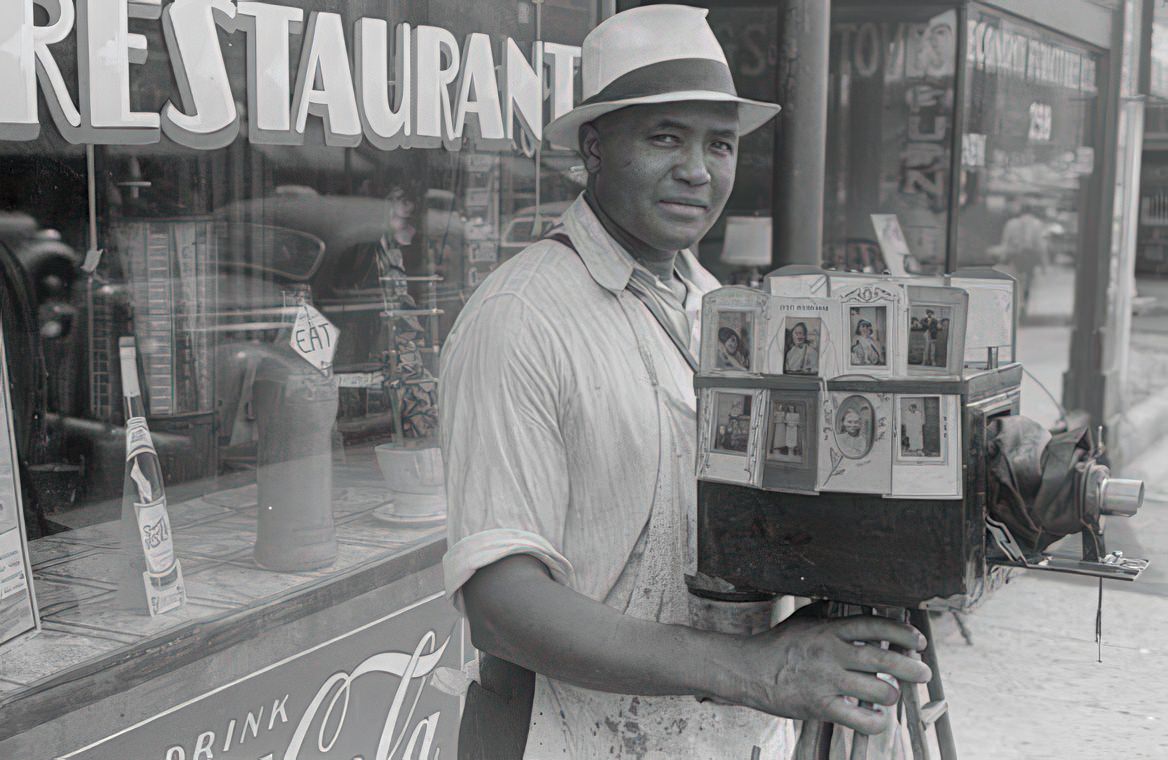 A traveling photographer shooting in Columbus, Ohio with his sidewalk portrait camera, 1938.