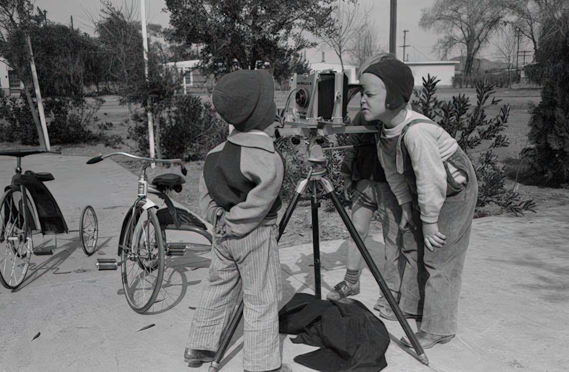 #3 Children at the FSA (Farm Security Administration) Camelback Farms inspect the photographer’s camera, Phoenix, Arizona, 1942.
