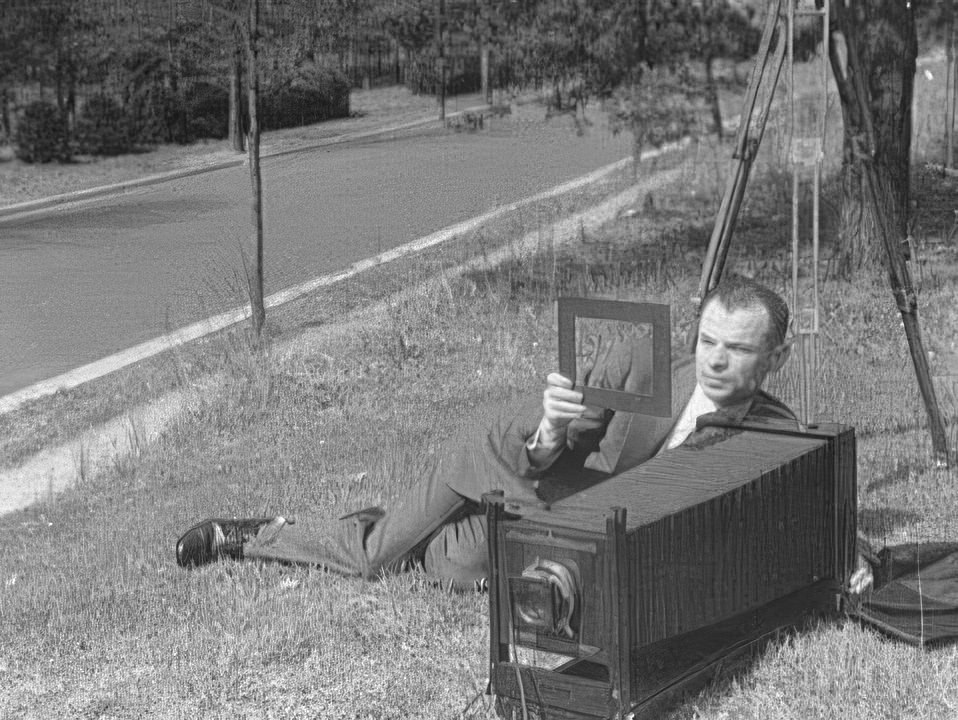 Theodor Horydczak lying on ground with camera in the early 1900s.