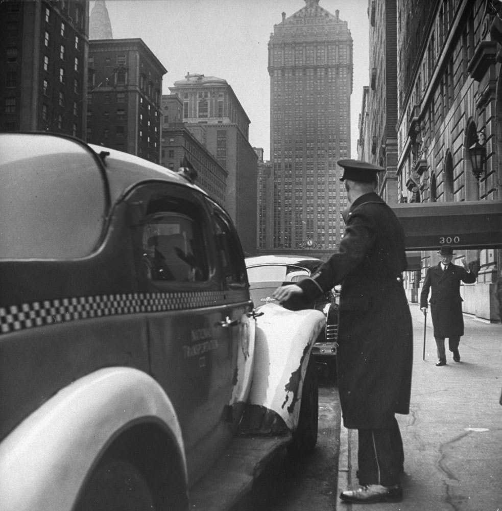 #1 A New York City doorman flags down a taxi for one of the residents of his building, 1944.