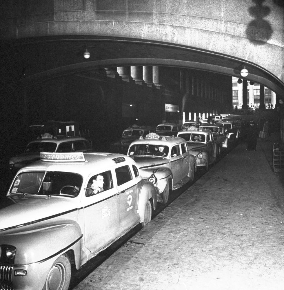 #4 Taxicabs line up for arriving train passengers at (the original) Pennsylvania Station, New York City, 1944.