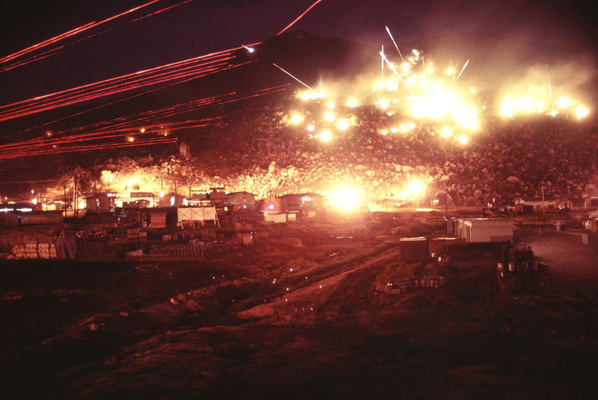 #2 Hand-launched flares illuminate the hills as soldiers fire M60 machine guns with red tracers. One round can be seen ricocheting near the top of the mountain.