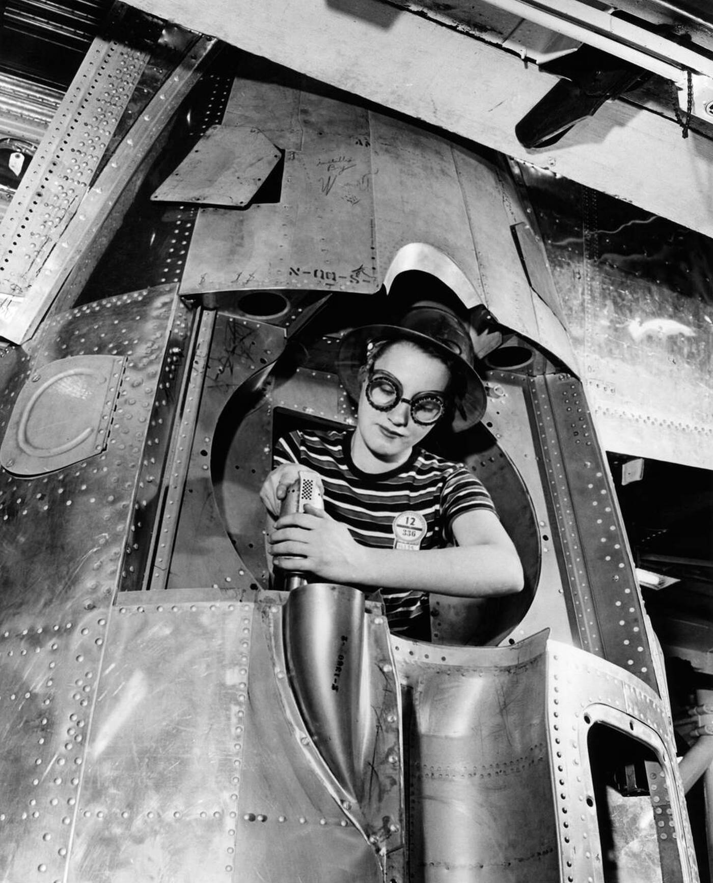 #115 A woman riveter drilling a hole, 1940s