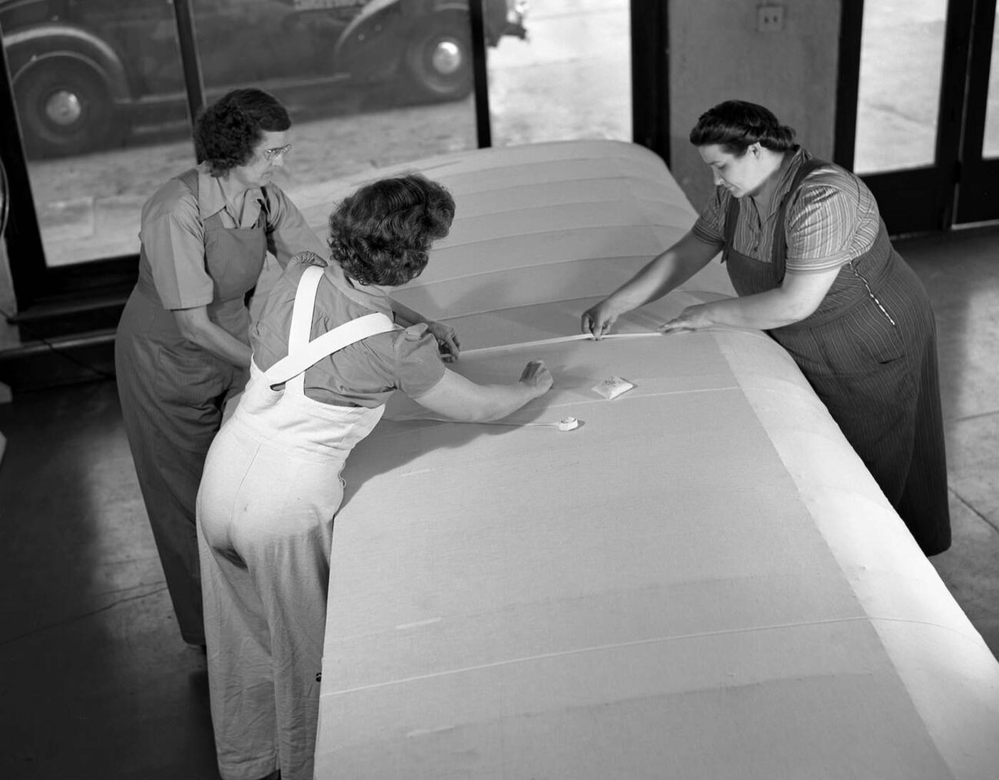 #88 Women sewing on an airplane wing, 1942
