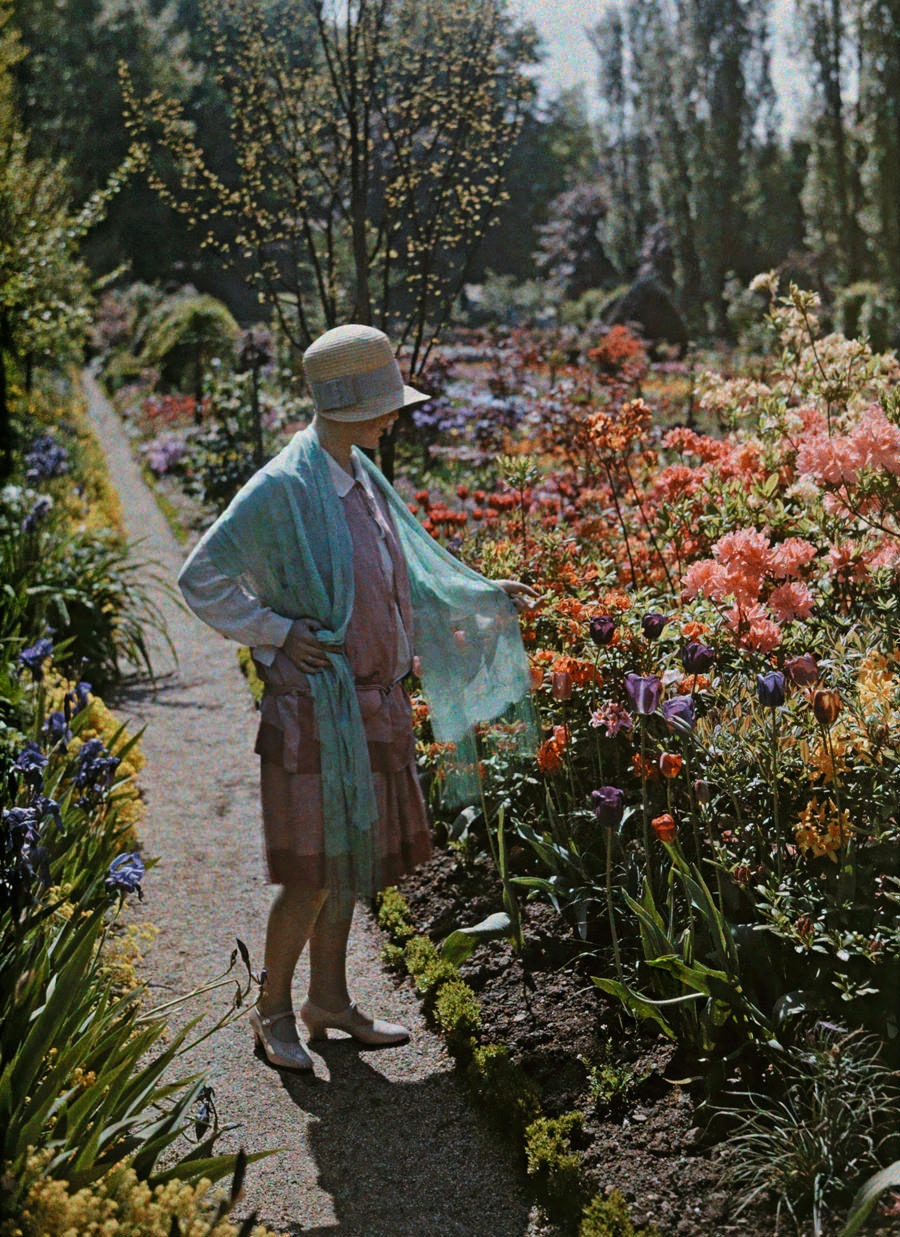 #16 A young woman admires flowers in a Baden garden in Germany, June 1928.