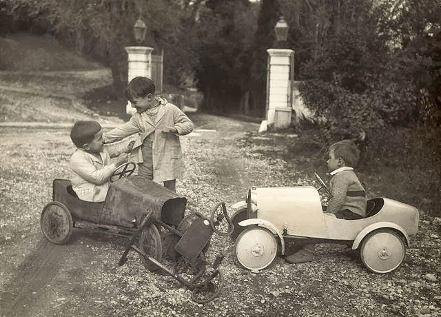 Little boys play after a traffic accident involving two toy cars and a tricycle, Netherlands, 1935.