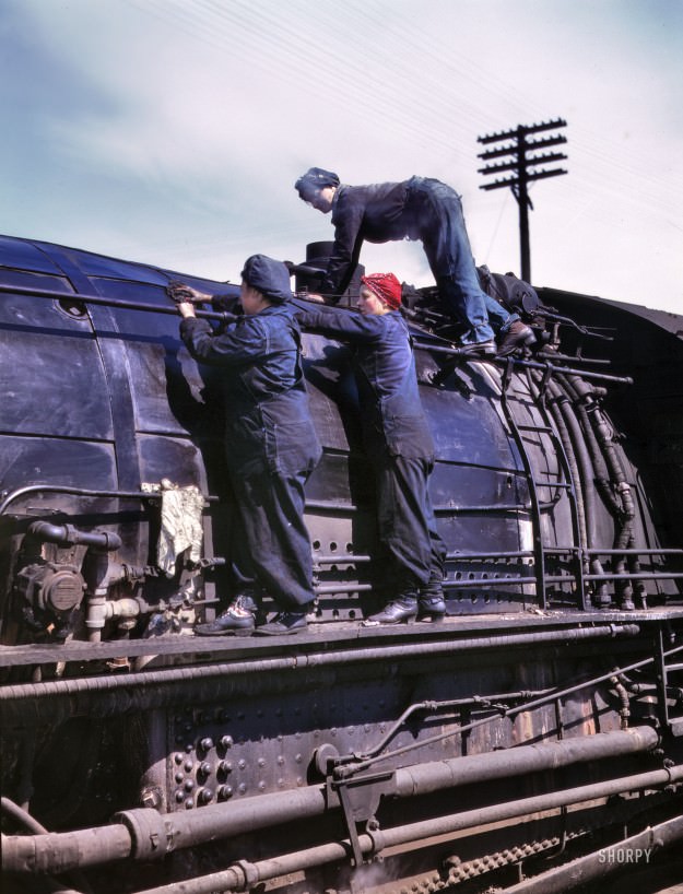 Clinton, Iowa. April 1943. “Chicago &; North Western Railroad. Women wipers at the roundhouse cleaning one of the giant H-class locomotives.” In the red bandanna: Marcella Hart, seen here in a few other posts. 4×5 Kodachrome transparency by Jack Delano for the Office of War Information.