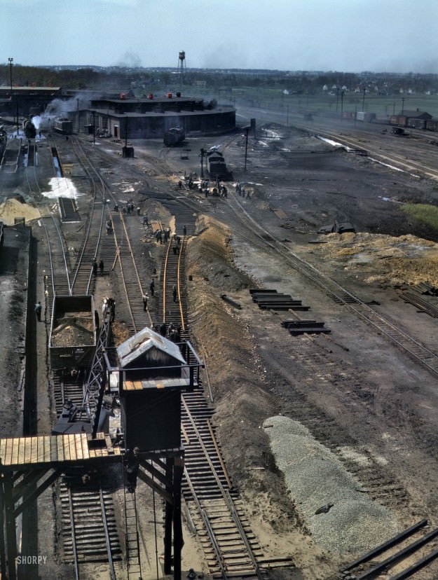 #23 May 1943. Bensenville, Illinois. “Bensenville yard of the Chicago, Milwaukee, St. Paul, and Pacific Railroad. Track repair and work on the cinder pits at the roundhouse.” 4×5 Kodachrome transparency by Jack Delano.