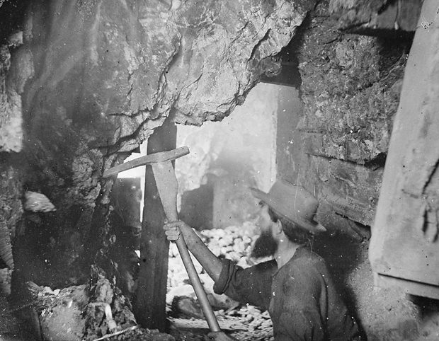#20 Miner working nine hundred feet underground at the Savage and the Gould and Curry mines on the Comstock Lode in Virginia City, Nevada. Taken in 1867.