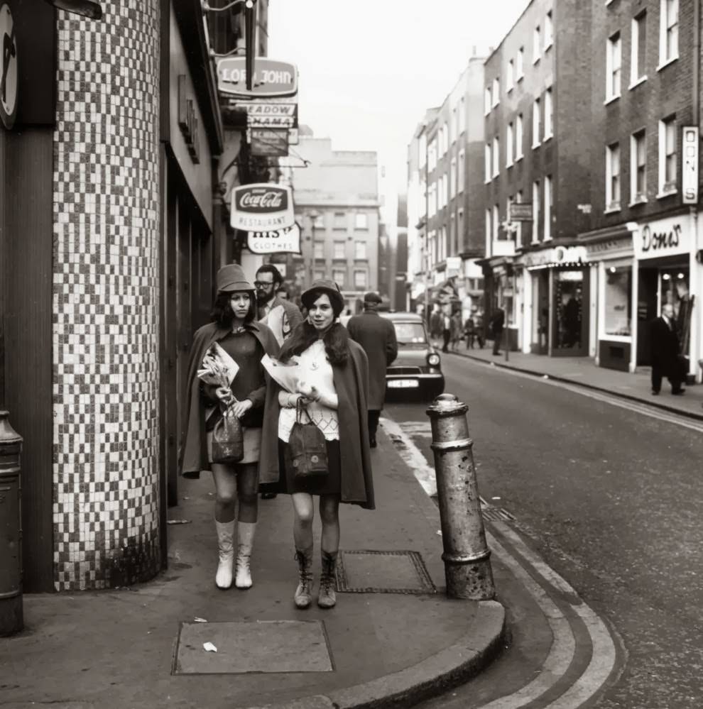 #3 circa 1967: Two young women walk down the street.