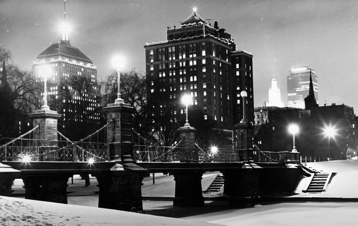 #29 Snow covers the Public Garden in Boston at night with the Berkeley Building and Prudential Tower in the background, 1966.