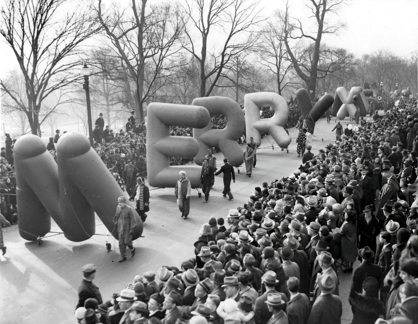 #13 Balloons spelling out “Merry Xmas” carried during the annual Santason parade in Boston, 1939.