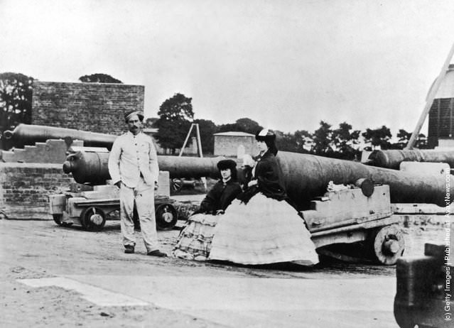 #22 A soldier and two women posing next to cannons during the Crimean War, 1850s.