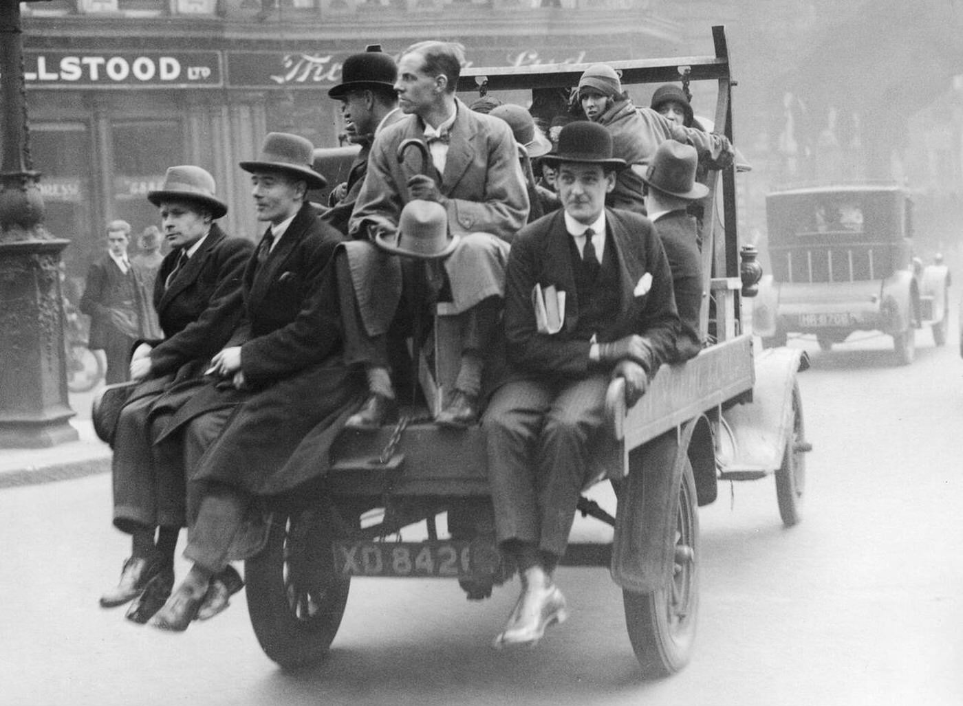 #30 Businessmen in London commute into the city on the back of a truck during a local transport strike.