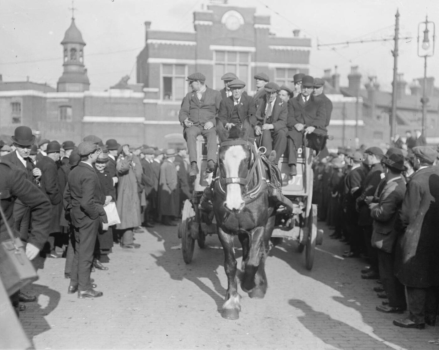 #33 March of ex-soldiers from Woolwich Arsenal to see the Premier with wounded men leaving the Arsenal in a cart, 1920.