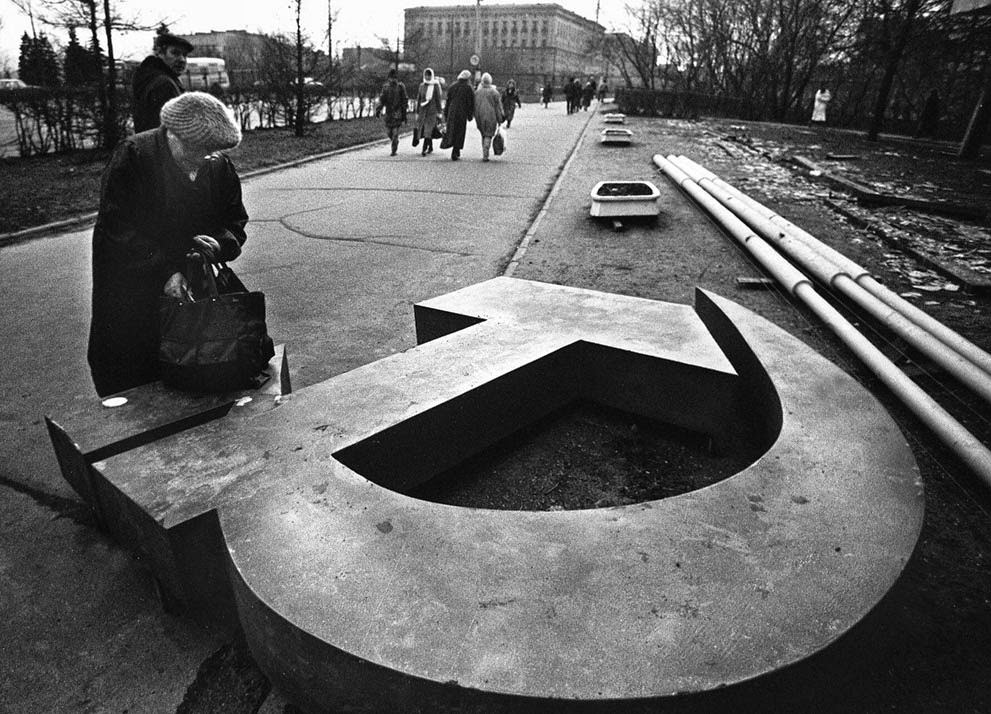#2 A woman reaches into her bag near a fallen Soviet hammer-and-sickle on a Moscow street, 1991.