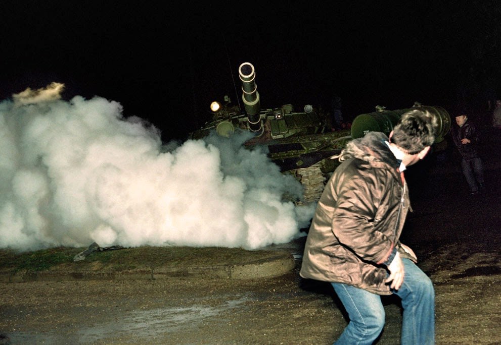 #13 A Lithuanian demonstrator runs in front of a Soviet Red Army tank during an assault in Vilnius, 1991.