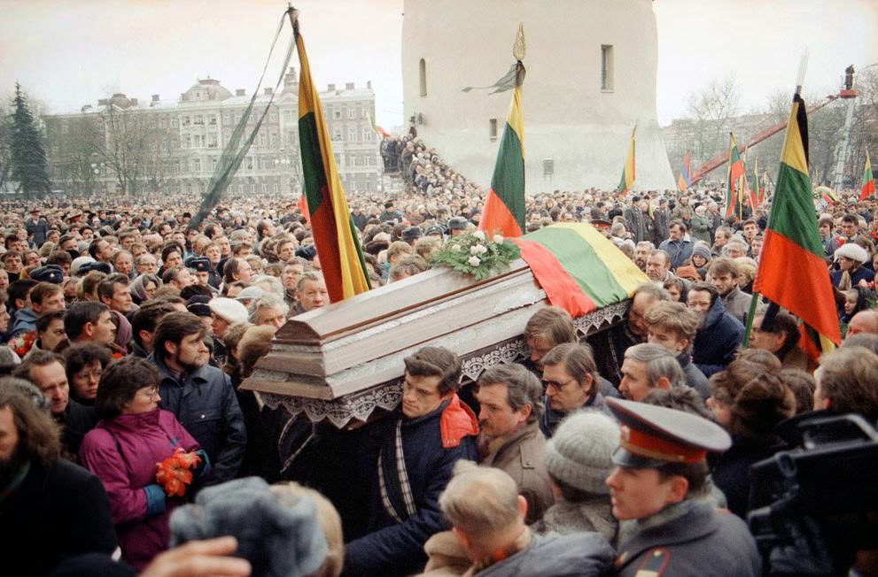 #15 Pall-bearers carry a flag-draped casket during a funeral procession in Vilnius, 1991.
