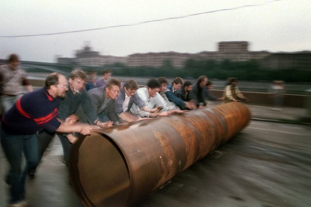 #21 Supporters of Russian president Yeltsin roll a large metal pipe to use as a barricade in Moscow, 1991.