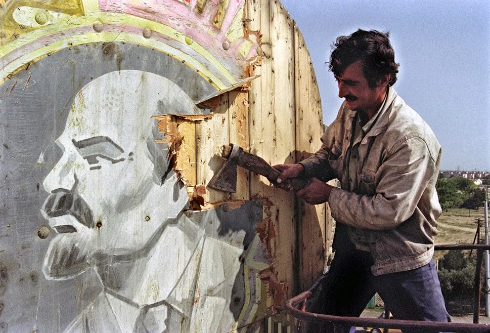 #37 A Baku resident uses an axe to hack apart a portrait of Vladimir Lenin, 1991.