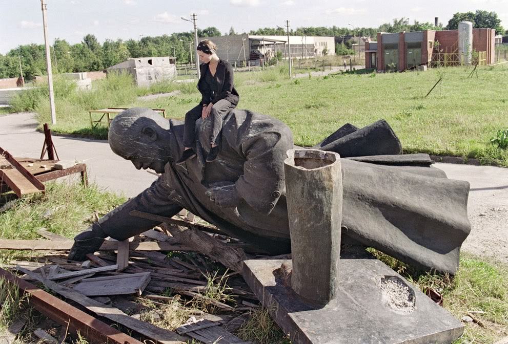 #40 A girl sits on the toppled statue of Vladimir Lenin in Vilnius, 1991.
