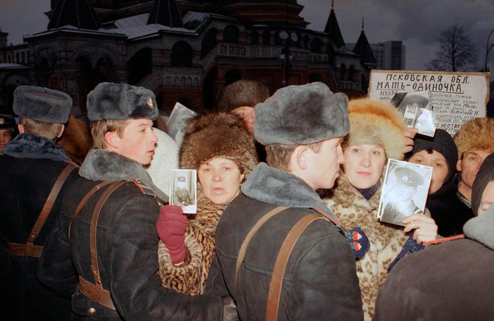 #9 Soviet mothers hold photographs of their sons lost in the Red Army in Red Square, 1990.