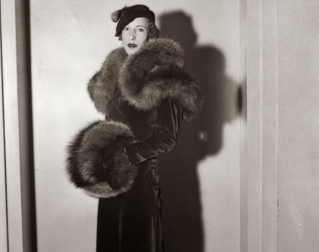 #18 Tres chic! A woman models an over the top red velvet ensemble during a fashion show in 1933.