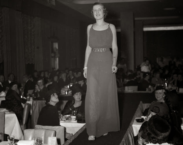 #21 The catwalk hasn’t changed much in over 75 years. Here, a model walks the runway at a 1935 society fashion show.