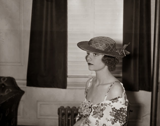 #25 A model wears a navy plaid silk bonnet during a 1935 fashion show … now if only she’d wear a smile!