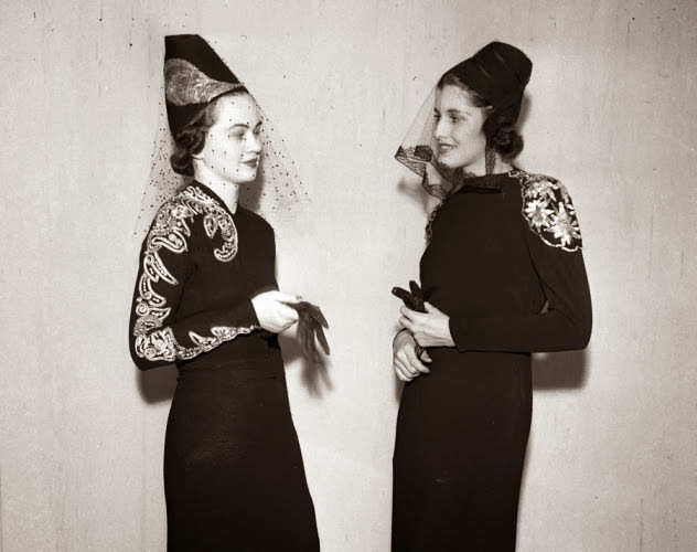 #7 That’s some interesting headwear! Two models wear hats with embroidered veils at a 1937 fashion show.