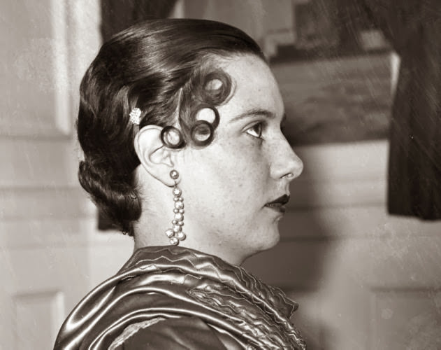 #8 Looking very severe, a model shows off a distinctly 1930s hairstyle with curls above the eye and her hair pulled tightly back.