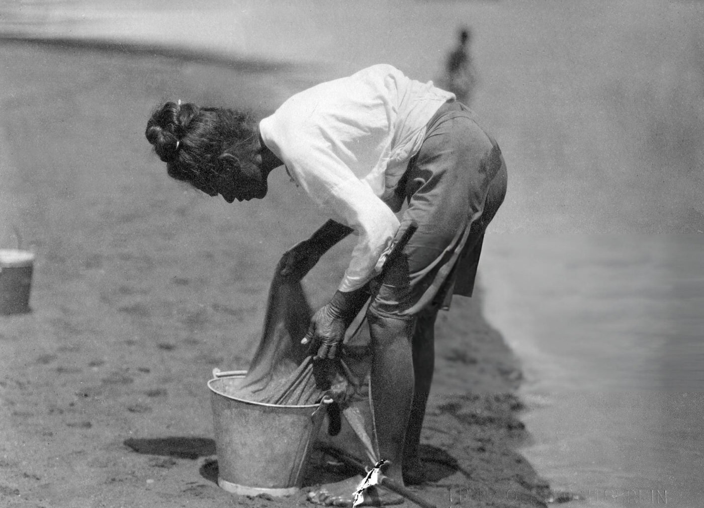 #36 Fisherwoman emptying her fishing net in Hawaii, 1910.