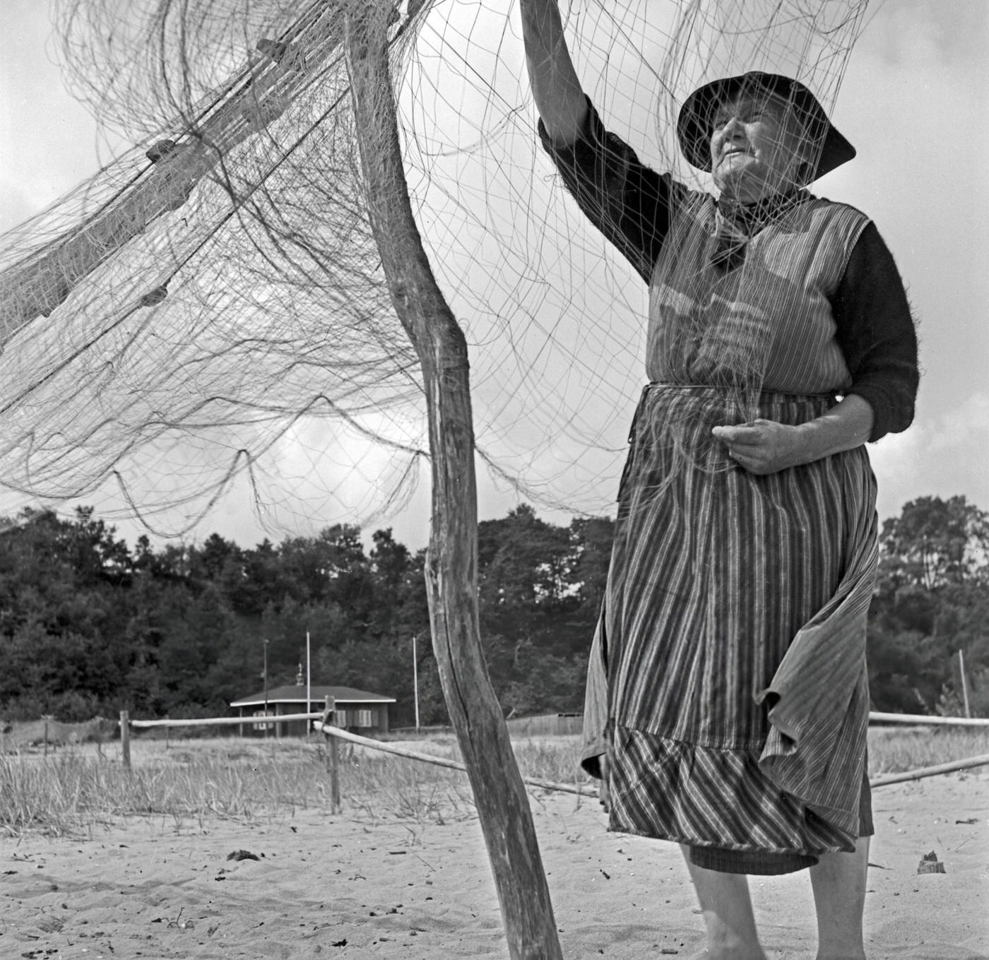 #53 A fisherwoman assorting his net at Rositten on the Baltic Sea in East Prussia, 1930s.