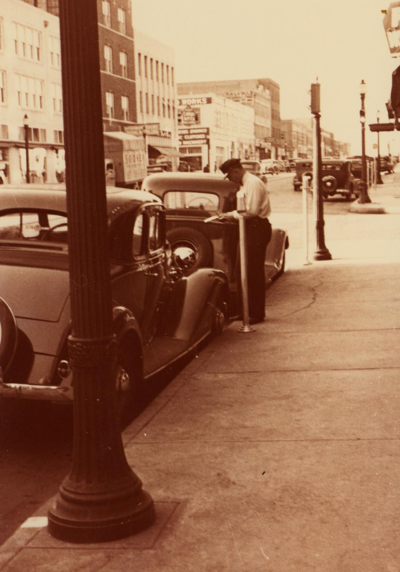 #113 A police officer writing a parking ticket, 1930s.