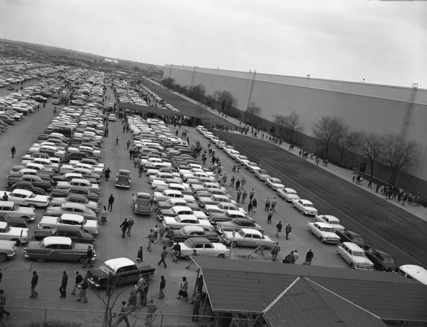 #50 An aerial view of a plant’s parking lot during a shift change, 1958.