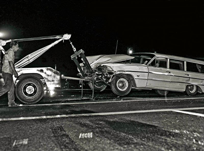 A 1964 Chevrolet wagon getting towed from the scene of an evening accident on the mean streets of Fresno, California, in the mid-1960s. The mis-matched color of the front end suggests this is the second time for this poor wagon