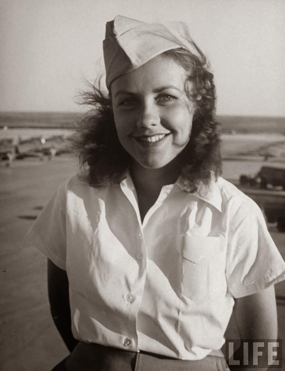 #7 Shirley Slade, pilot trainee in Women’s Flying Training Detachment, sporting an official dress uniform of white blouse, tan slacks and overseas cap, during training at Avenger Field.