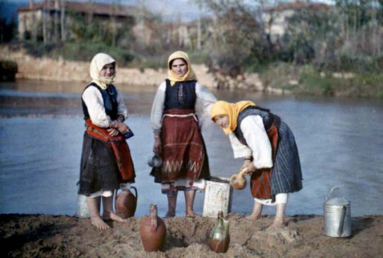 Women filter water taken from riverside pools to use for drinking, near Jugoslavian Frontier.