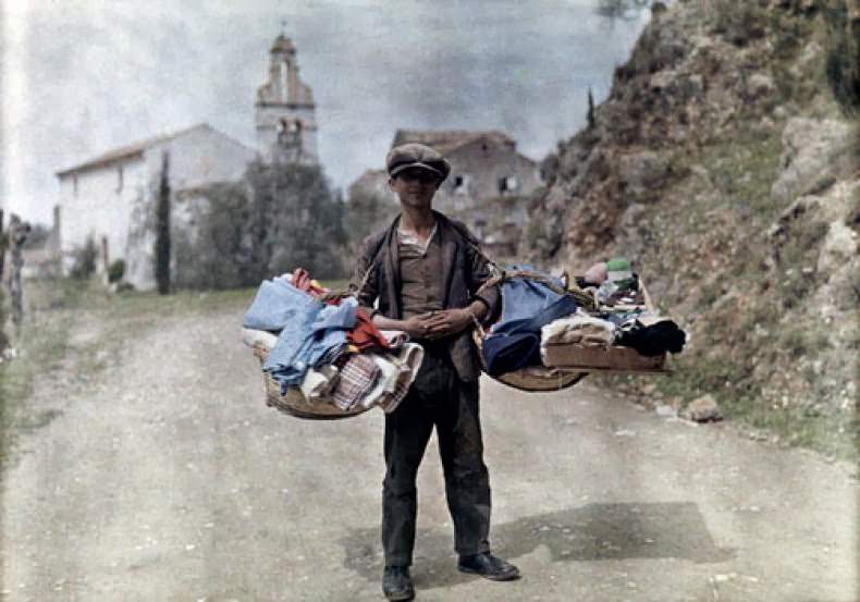 A peddler with his wares passes through the village, Gastouri, Corfu.