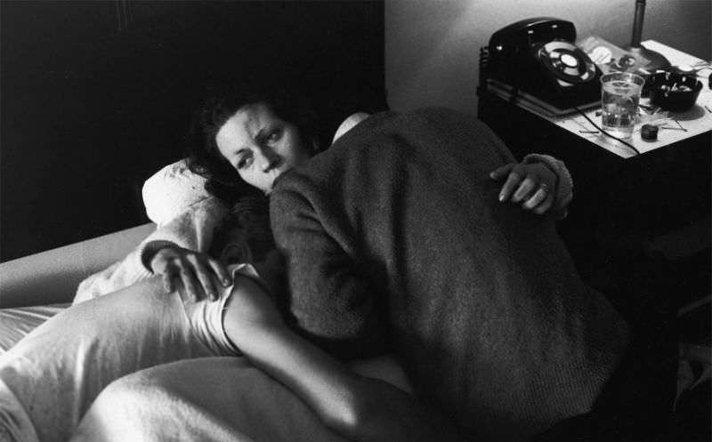 #9 Karen with her arms around boyfriend Johnny and his brother, Bro, who is also an addict, as they lie hopelessly on a hotel bed.