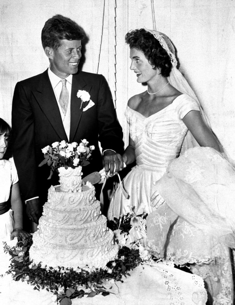 #25 President John F. Kennedy and his wife Jacqueline cut the wedding cake, Newport, Rhode Island, 1953.