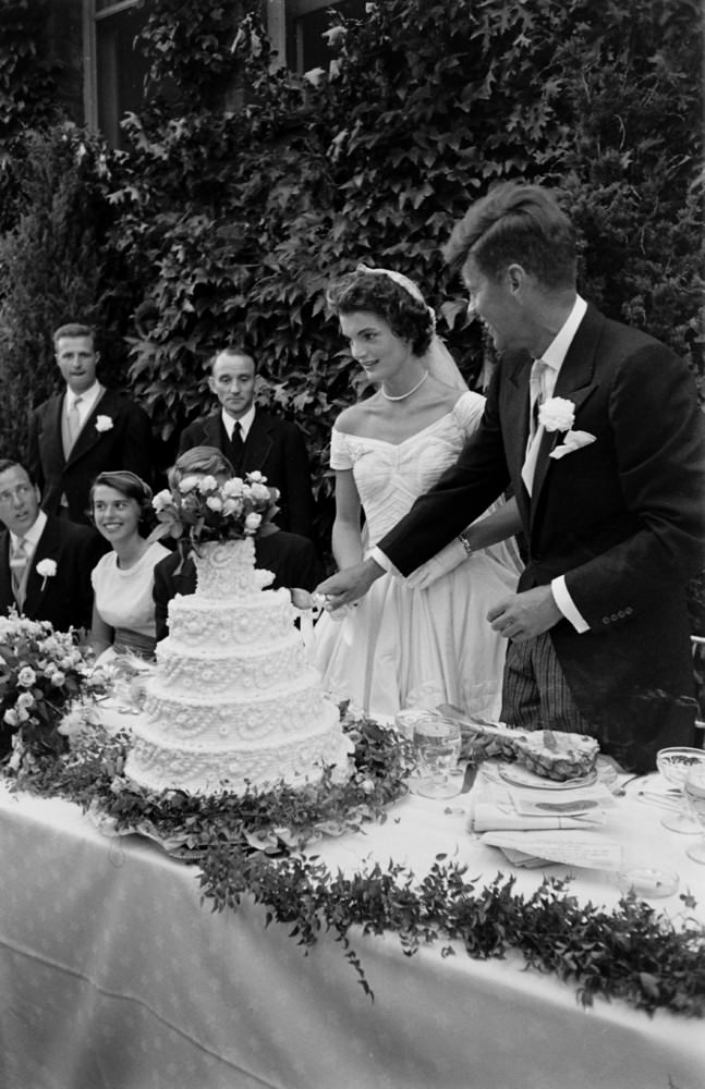 #26 John F. Kennedy and Jacqueline Kennedy cut the cake at their wedding reception, Newport, Rhode Island, 1953.