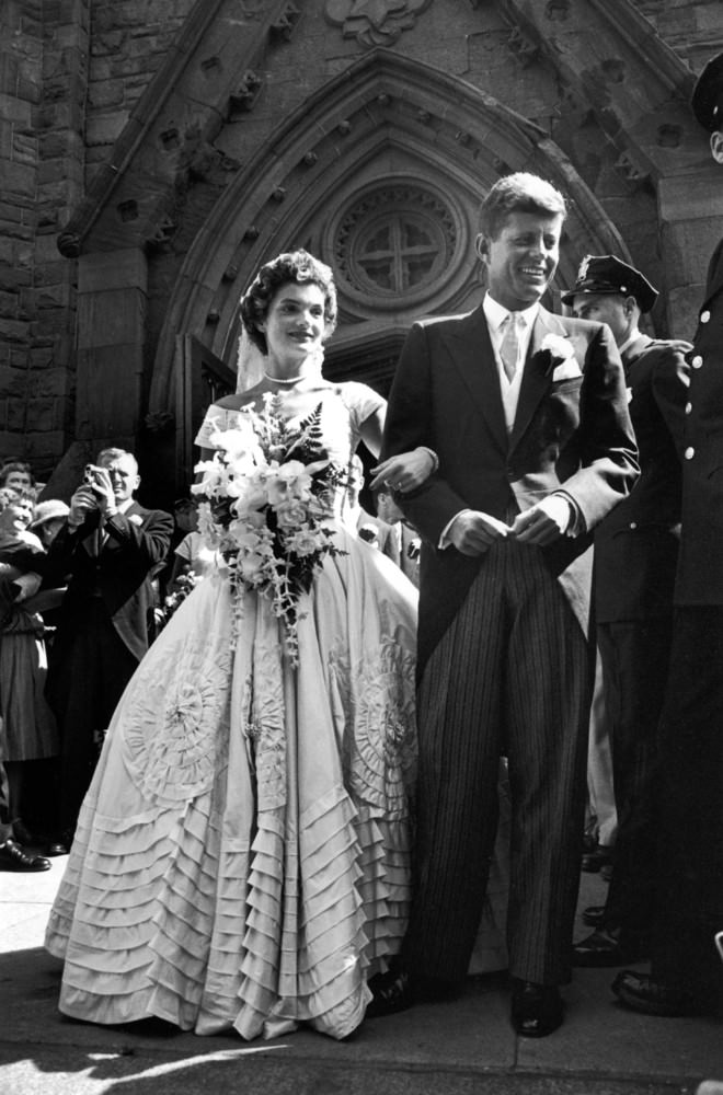 #10 Jacqueline Bouvier in her wedding dress with her husband, Senator John Kennedy, after their wedding ceremony, 1953.