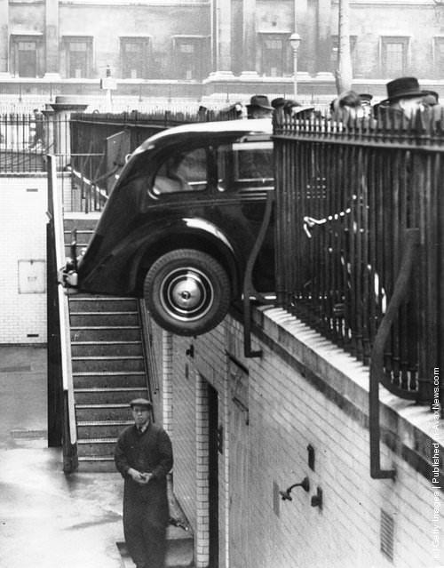 A car crashed through railings and hangs over the basement of Canada House, Trafalgar Square, 1939.