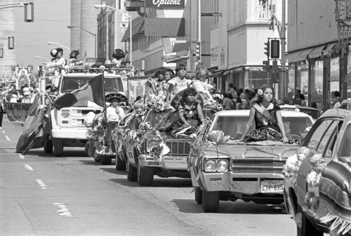 #12 Two candidates for the Mexican Independence Day Fiesta Queen wave from cars in Fort Worth, Texas, 1977.