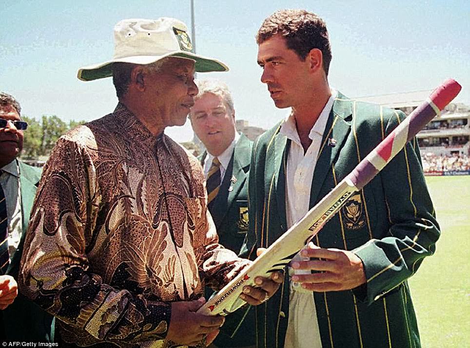 #22 South African President Nelson Mandela receives a cricket bat from the South African Cricket captain, Hansie Cronje, during the lunch break on the third day of the Second Test between South Africa and India at Newlands on January 4, 1997.
